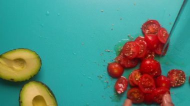 Top view of person hands preparing avocado and tomatoes                 