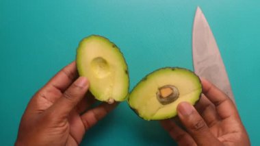 Top view person hands cutting avocado