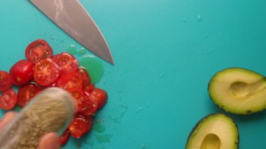 Top view of person hands preparing avocado and tomatoes                 