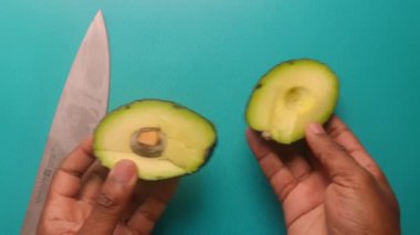 Top view person hands cutting avocado