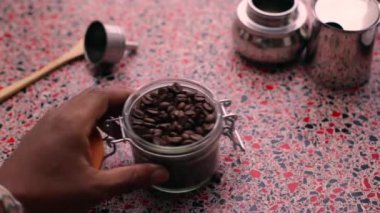 Mutfakta kahve çekirdeklerini elle öğüten biri var.
