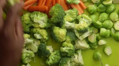 Mutfakta sebze doğrayan şefin yeşil tahtadaki manzarası.