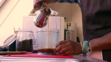 Evde tereyağı ve MCT yağıyla sağlıklı kahve hazırlayan kişi