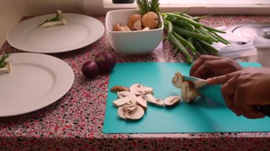 Closeup chef chopping organic mushrooms in kitchen