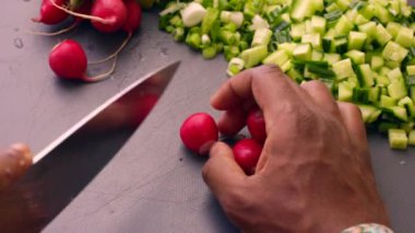 Closeup chef hands chopping organic radish in kitchen