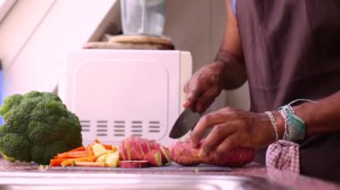 Adam sağlıklı yemek için organik tatlı patatesleri doğruyor.