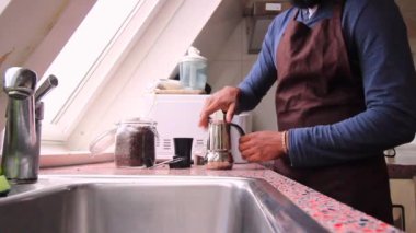 Mutfakta kahve demliği hazırlayan kişi.
