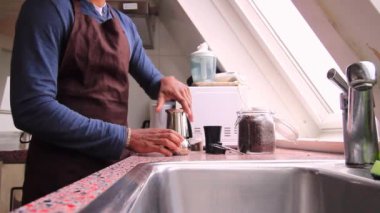 Mutfakta moka demliği ile espresso yapan adam.