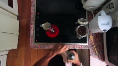 Kahve çekirdeklerini öğüten ve kahve demliğiyle espresso hazırlayan biri.