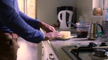 Adult male making keto coffee with butter and MCT oil at home 