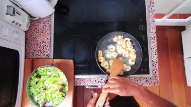 Top view of chef preparing healthy salad with shrimps in kitchen