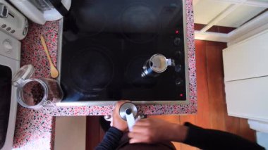 Kahve çekirdeklerini öğüten ve kahve demliğiyle espresso hazırlayan biri.