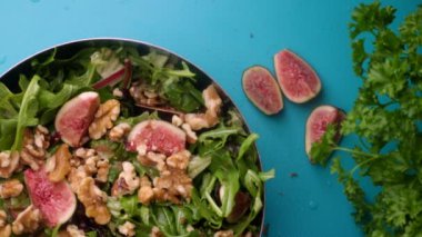 Preparing fresh salad with figs and walnuts