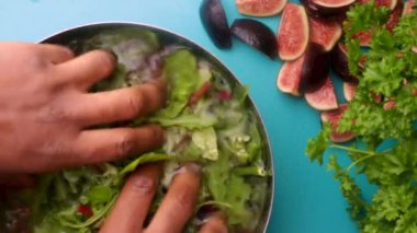 Video shows a person mixing a bowl of green salad with figs for a healthy meal. 8 seconds video 