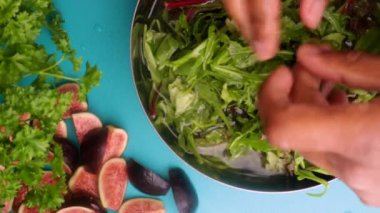15 seconds video. Video of a person preparing a fresh, healthy salad with greens and figs.