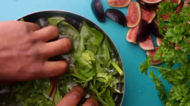 15 seconds video. Video of a person preparing a fresh, healthy salad with greens and figs.
