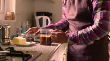 Evde tereyağı ve MCT yağıyla kahve yapan bir yetişkin.