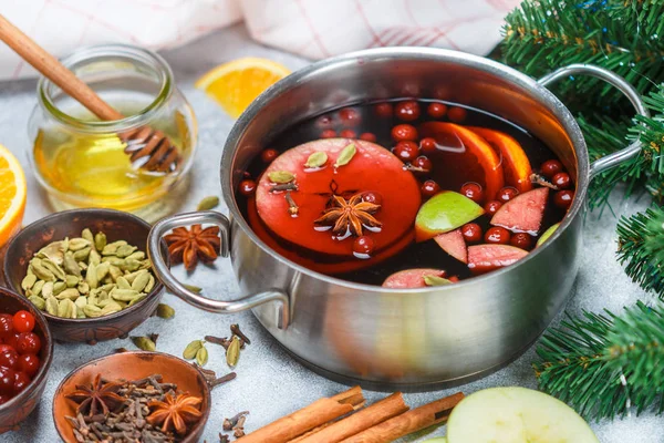 Mulled wine is a traditional winter drink with red wine, honey, orange, green Apple, cranberry and spices - cinnamon, cardamom, star anise, cloves, ginger, pepper. grog. punch. Christmas. New year. Selective focus