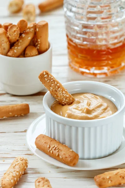 Bread sticks with sesame seeds with mustard and honey dip sauce. Gourmet snack for gourmets. Selective focus