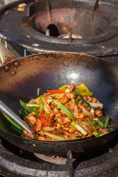 Street food. Fry the meat in a wok with vegetables