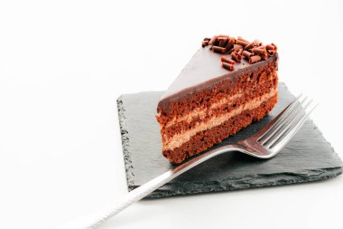 Siyah taşın üzerinde çatal olan bir parça çikolatalı pasta. Yukarıdan görünümü. Konsept menüsü.