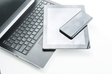 Bilgisayar, tablet ve akıllı telefon beyaz arka planda masanın üstünde. Elektronik ürünler satma kavramı