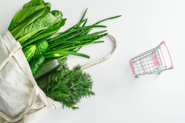 Süpermarketten alınmış mini-sepetli kumaş bir çantada sebzeler. Marketteki sebze fiyatları konsepti. Yukarıdan manzara. Sağlıklı beslenme. Metin için boş alan. Sebze çantası.