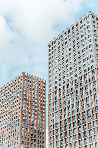 Mavi gökyüzüne karşı iki yeni bina. Yeni apartman inşaatı. İnşaatta müteahhit yatırımı. İnşaatın tamamlanması