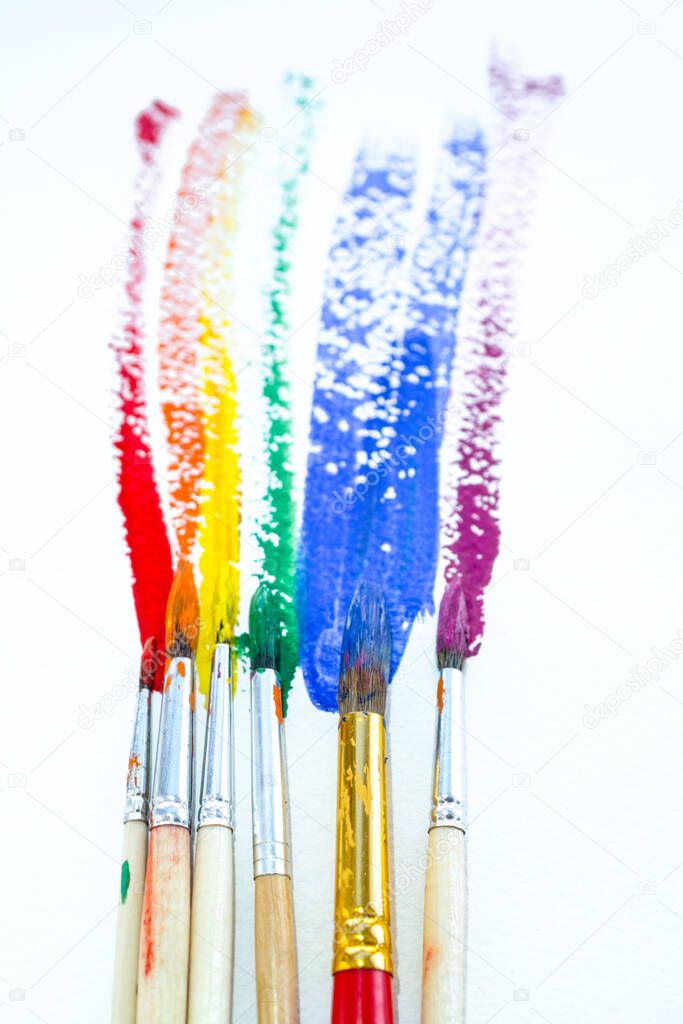 Cans of colored paint gouache with colored stripes and brushes