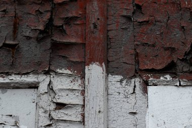 Eski ahşap kapı eski çatlak ve yapışkan kırmızı ve beyaz boyayla boyanmış. Grunge tasarımın için yakın plan bir fotoğraf çekildi..