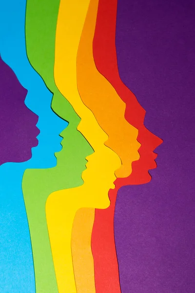 Nemsemleges Szivárványszínű Profilok Papírból Vannak Kivágva Függőleges Papírkép Lila Alapon Stock Kép