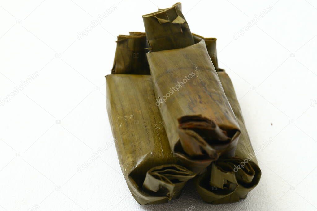 arem-arem or lemper is traditional food from java. Arem-arem made from rice cake containing vegetables or sambal or meat and chicken wrapped in banana leaves. isolated on white background