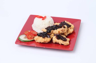 Kırmızı tabakta kızarmış tavuk ve pilav. Beyaz arka planda siyah baharatlı.