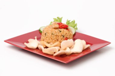 Endonezya yemeği: kızarmış pirinç (nasi goreng) beyaz arka planda kırmızı tabakta karides krakerleri servis edilir.