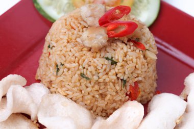 Endonezya yemeği: Kızarmış pirinç (nasi goreng) beyaz arka planda izole edilmiş beyaz tabakta karides krakerleri servis edilir.