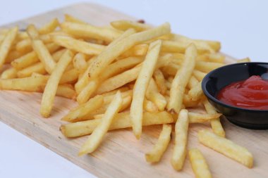 Lezzetli patates kızartması ya da kentang goreng kesim tahtasında, ahşap masa üzerinde, beyaz arka planda izole
