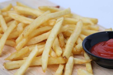 Lezzetli patates kızartması ya da kentang goreng kesim tahtasında, ahşap masa üzerinde, beyaz arka planda izole