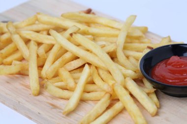 Lezzetli patates kızartması ya da kentang goreng kesim tahtasında, ahşap masa üzerinde, beyaz arka planda izole