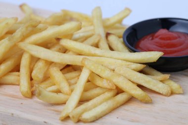 Lezzetli patates kızartması ya da kentang goreng kesim tahtasında, ahşap masa üzerinde, beyaz arka planda izole