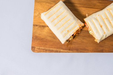 Izgara Shawarma evde sebzeli ve soslu ince bir lavaş tavuğun içinde hazırlanır.