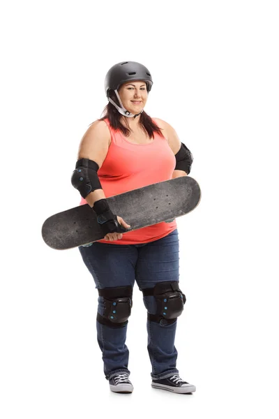 白い背景に分離されたスケート ボードを持って防護服を身に着けている太りすぎの女性の完全な長さの肖像画 — ストック写真