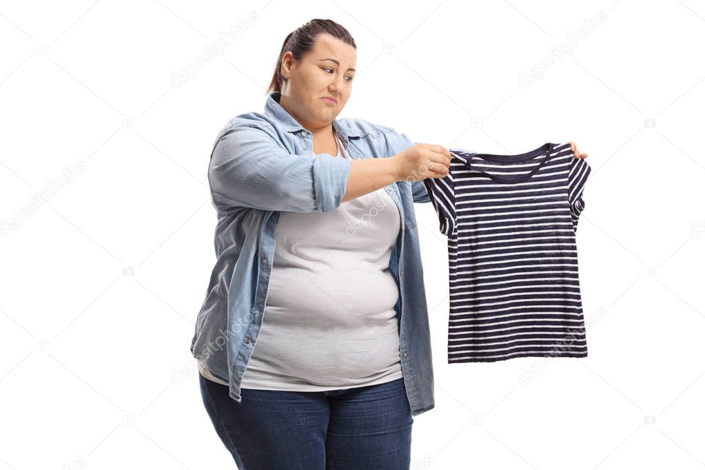 Sad overweight woman with a shrunken shirt isolated on white background