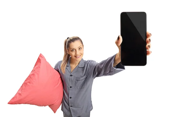 穿着睡衣的年轻女子抱着一个枕头和一个在白色背景下的电话 — 图库照片