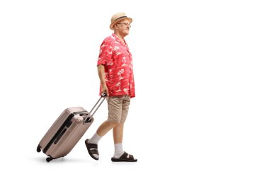 Tam uzunlukta profil yürüyüş ve beyaz arka plan üzerinde izole bir bavul çekerek yaşlı bir turist vurdu