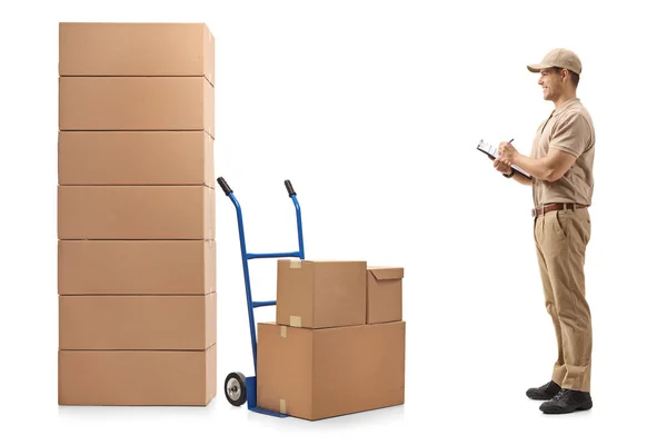Full Length Profile Shot Delivery Man Looking Stack Boxes Writing — Stock Photo, Image
