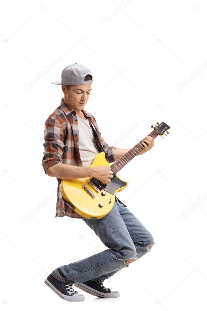 Full length portrait of a teenager playing an electric guitar isolated on white background