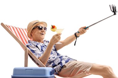 Bir kokteyl bir güverte sandalyede oturuyor ve beyaz arka plan üzerinde izole bir sopa ile bir selfie alarak yaşlı Turizm