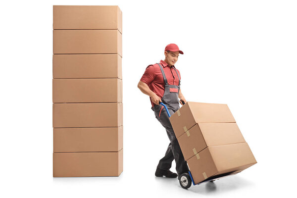 Mover with a hand truck next to a stack of boxes isolated on white background