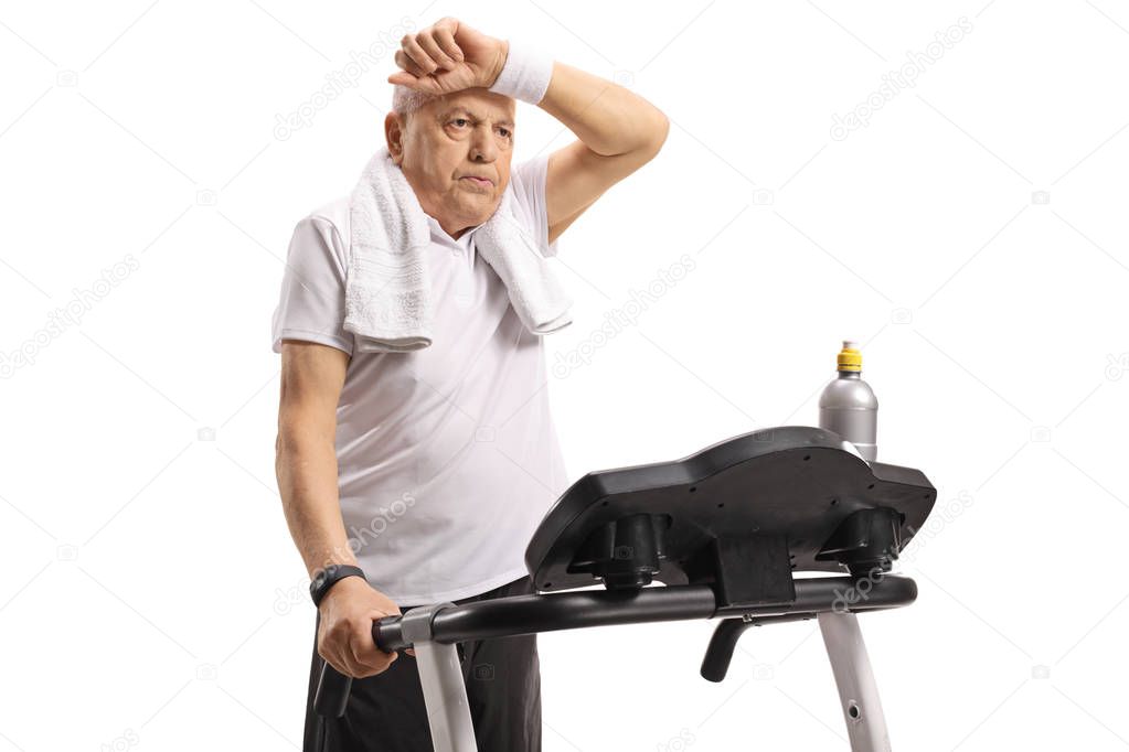 Exhausted senior on a treadmill isolated on white background