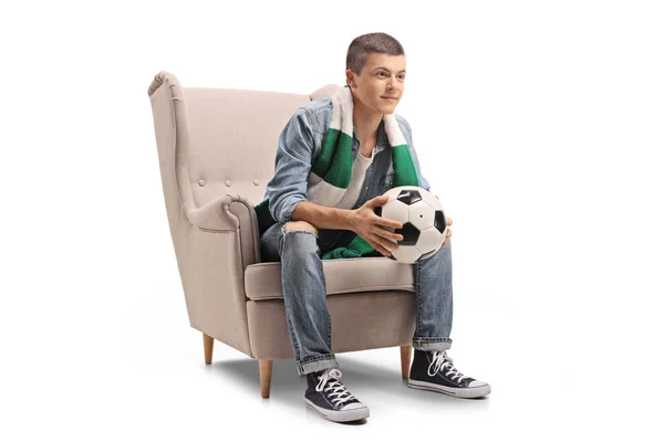 代のサッカー ファンのサッカーと白い背景に分離された肘掛け椅子に座ってスカーフ — ストック写真